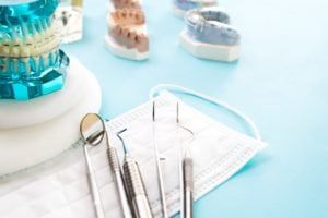 Dental models of teeth, dental tools, and braces on a dental model